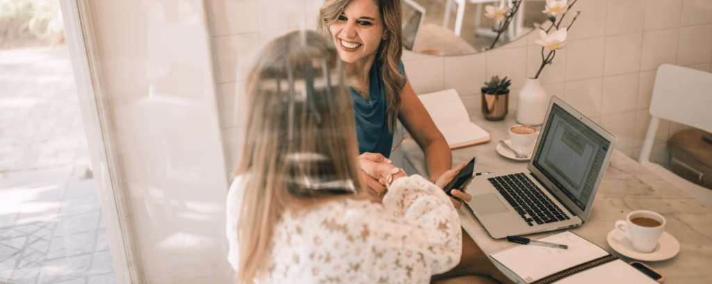 Business owner with an Illinois business insurance greets a client in cafe