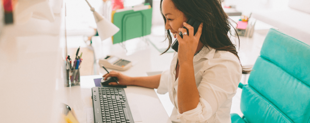 Business owner works at computer on phone
