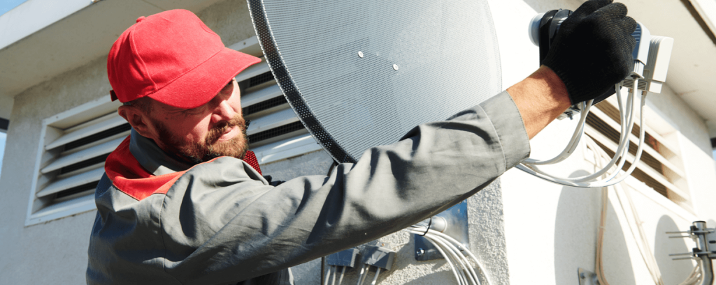 Satellite installer works on ladder