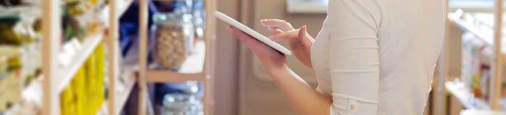 Woman wearing a writer long sleeve shirt and scrolling on her tablet