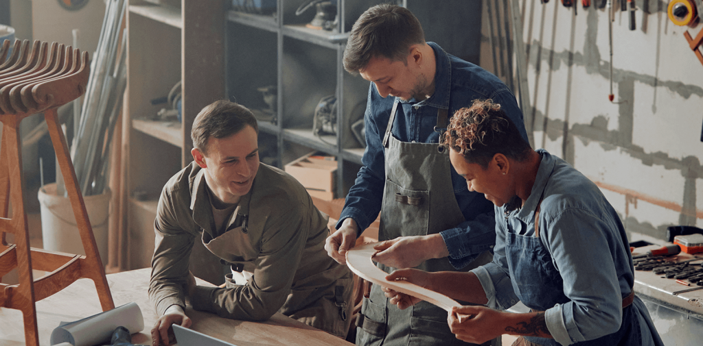 Three workers who have workers’ comp insurance are discussing a project


