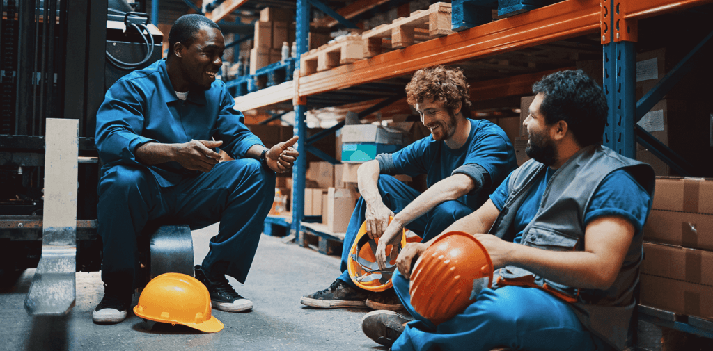 Three workers who have workers' compensation insurance are talking to each other

