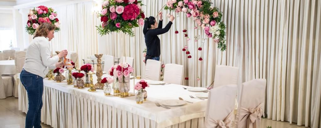 Two women arranging flowers at a wedding reception