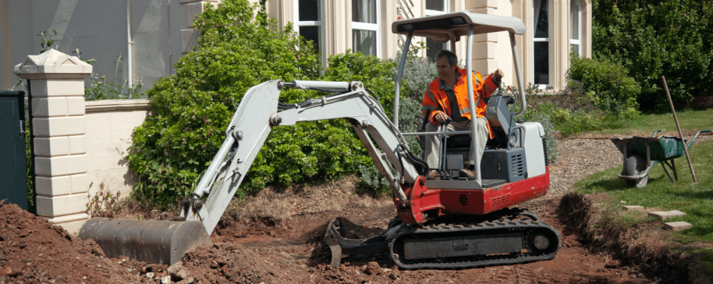 Man operating small backhoe