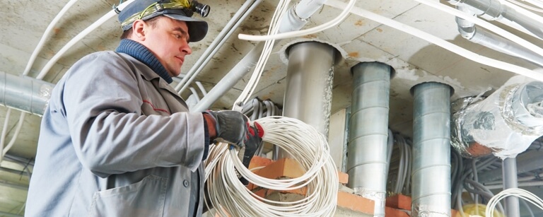 Cabler installing cables in factory