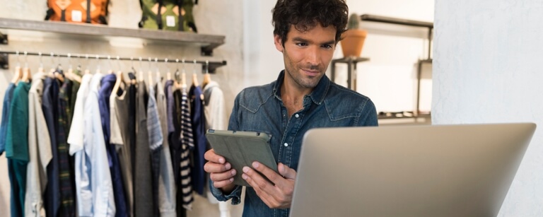 Clothing shop employee standing at register