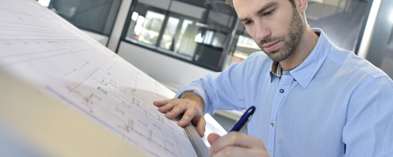 Draftsman using ruler at desk