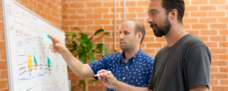 Engineers plotting work on a whiteboard