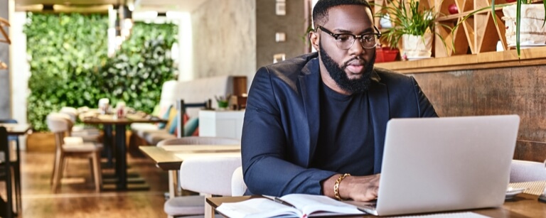 Freelancer works at laptop in coffee shop