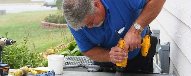 HVAC technician repairing residential AC unit