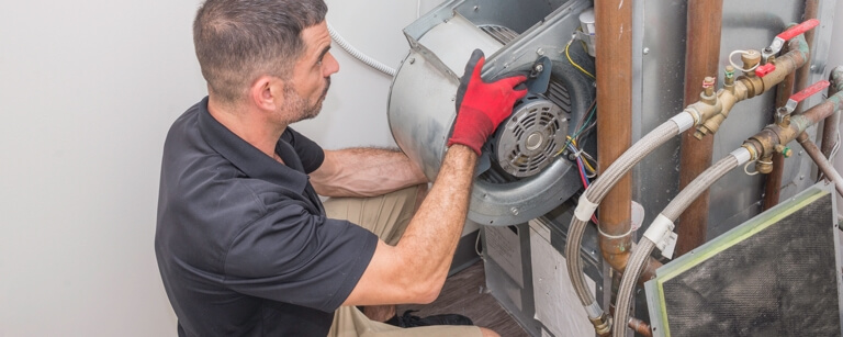 HVAC technician repairing commercial AC unit on roof