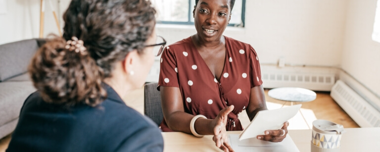 A lawyer meeting with a client using a tablet