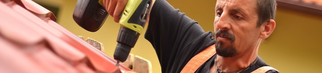 A man using a drill to install a roof