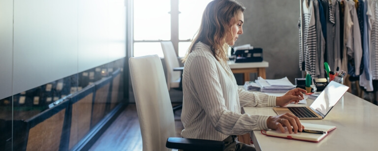 Retailer working at desk with laptop