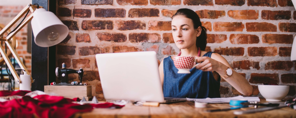 Tailor with a Colorado business insurance checks her email on a laptop 

