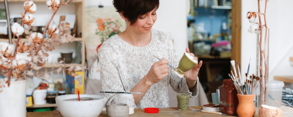 Pottery store owner paints mug