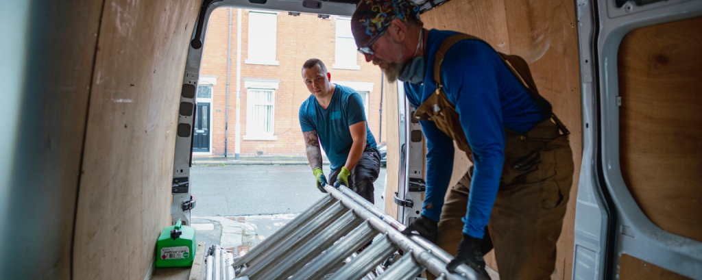 Contractors with South Carolina business insurance remove ladder from a van 

