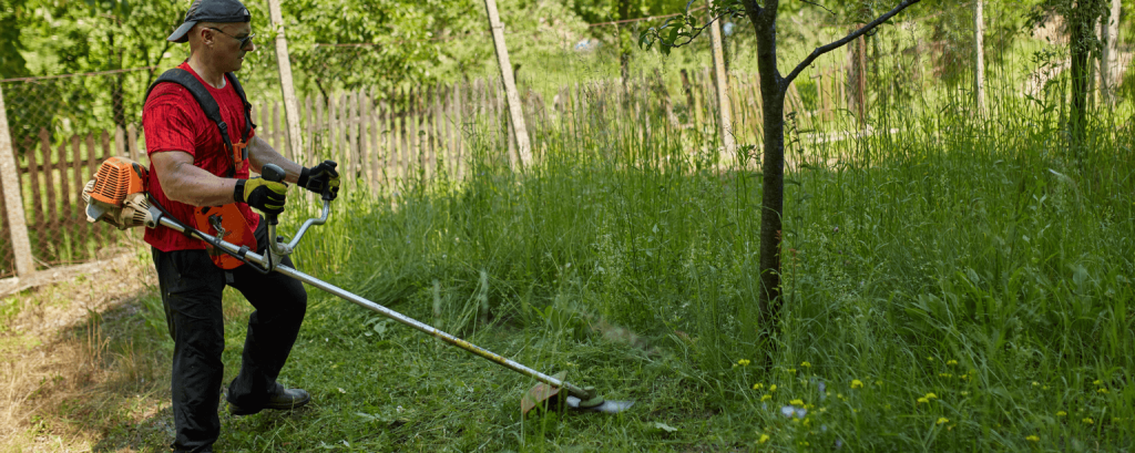 Lawn care worker using weed-whacker