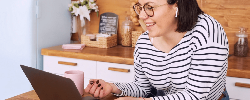 Small business owner works on laptop in kitchen