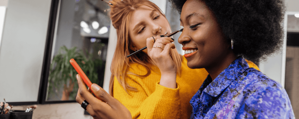 Make up artist applies eye shaddow to client