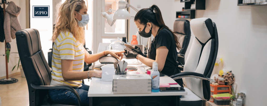Nail technician works with client
