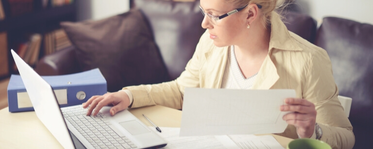 An insured tax preparer is reviewing forms on her laptop

