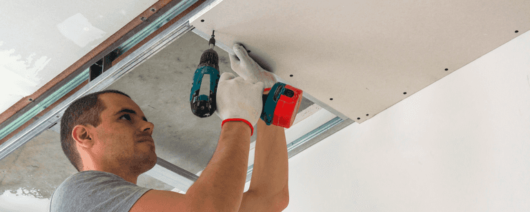 Contractor installs ceiling tiles
