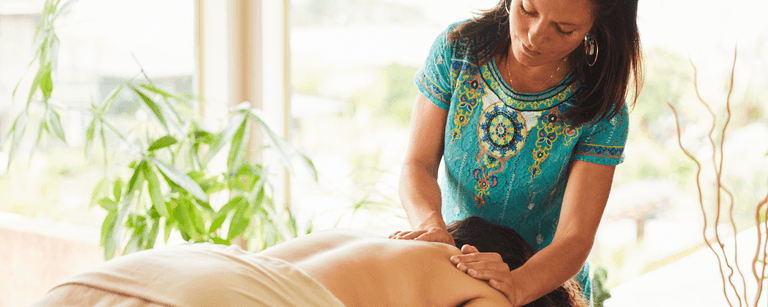 Massage therapist massages client's back
