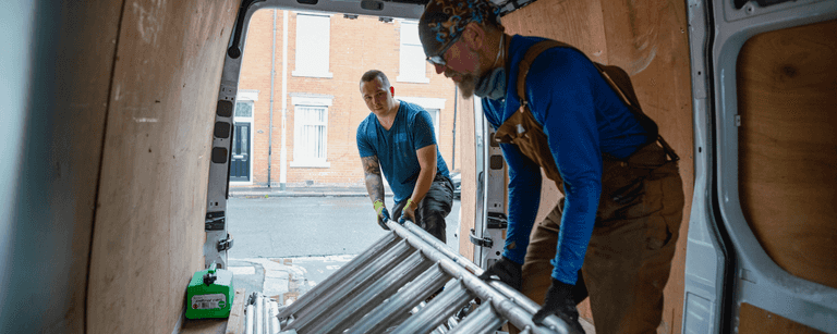 Contractors remove ladder from van