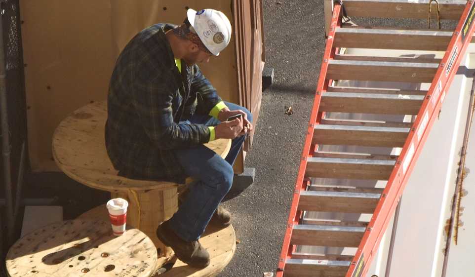 Contractor marketing tips can be easy to implement right from your phone, like this contractor at his job site.