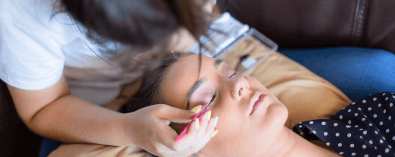 Make-up artist applies eyelashes to client