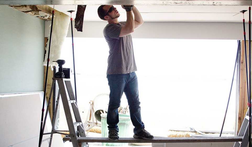 Getting a general contractor license CA means you can legally start working on projects, like this tradesperson working on a ceiling.