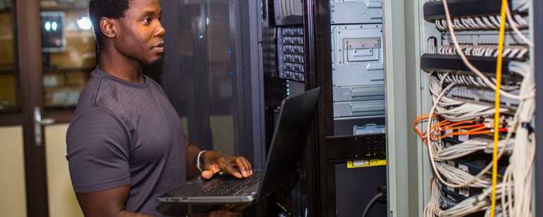 IT contractor checking server performance with laptop