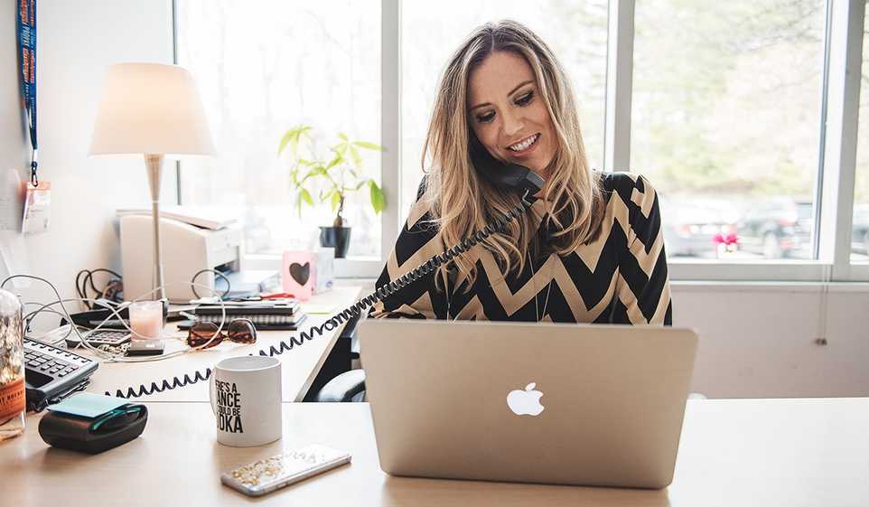 One of the top strengths of a woman entrepreneur is multi-tasking, as this small business owner is demonstrating at her desk.