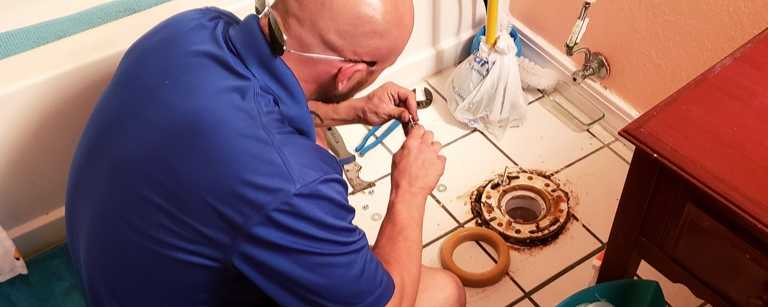 A plumber installing a toilet