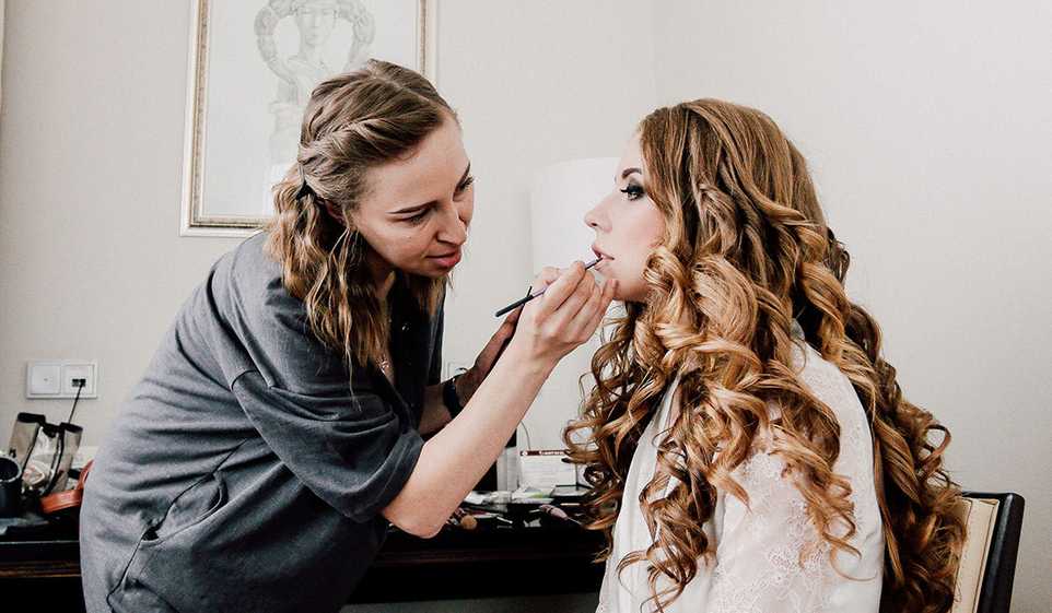 Getting your makeup artist license can make it easier to get customers, like this makeup artist working on a client.