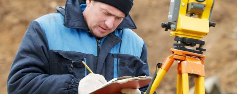Land surveyor writing notes on clipboard