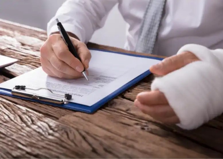 Man with a cast on left arm fills out a form.