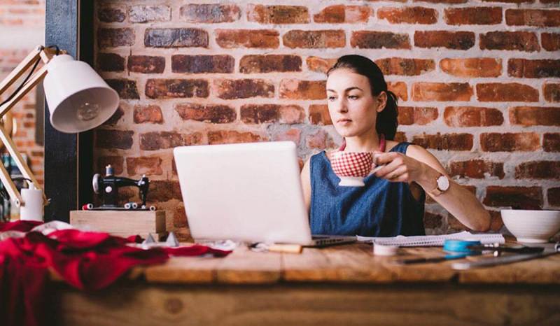 A woman sits at her laptop while she researches best banks for small businesses