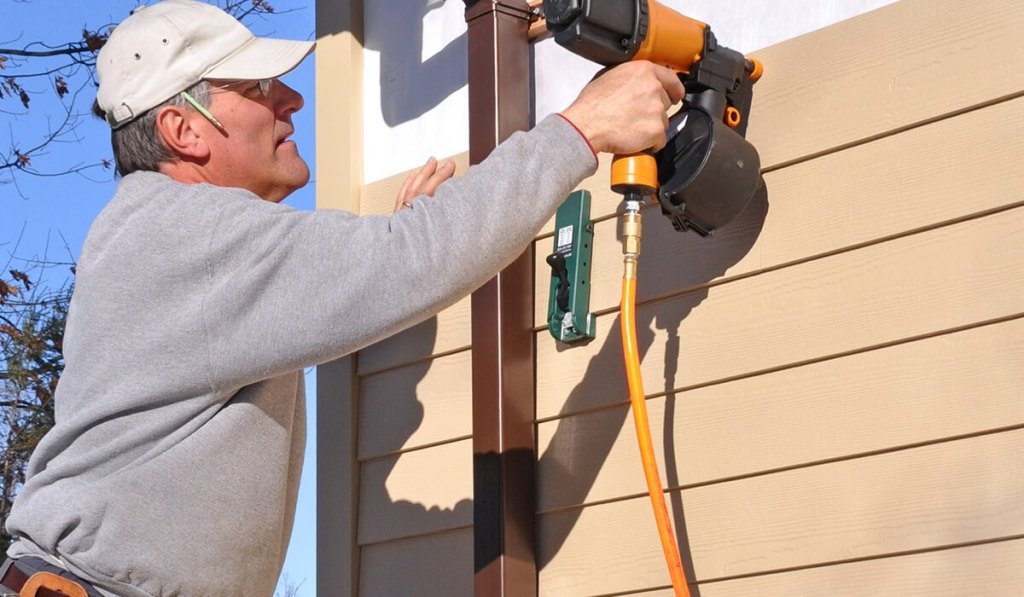 A man who owns Rhode Island Contractors License working on a client’s house