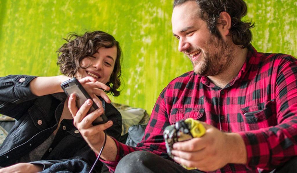 Man and woman sit and laugh together while looking at funny handyman business names