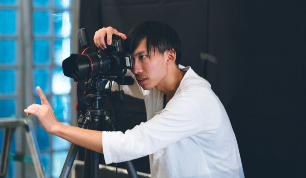 Freelancers - like this photographer on a set - should protect themselves from lawsuits with freelance business insurance.