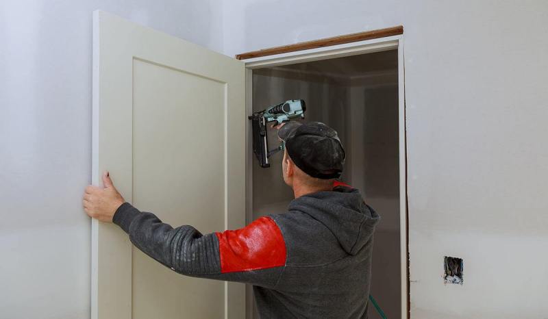 contractor working on door pane with drill tool