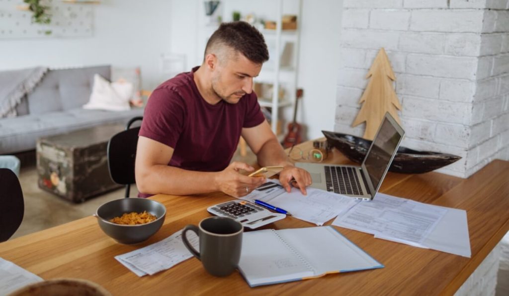 A small business owner fills out paperwork for his SBA 7(a) loan.