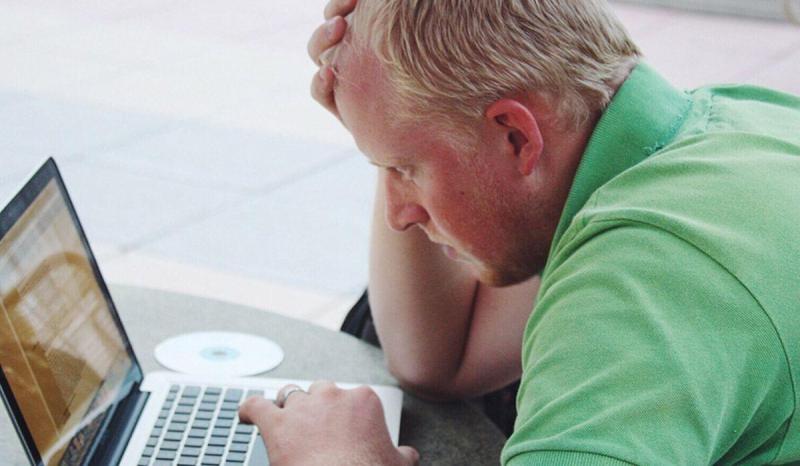 A man looks frustrated because he is dealing with difficult customers
