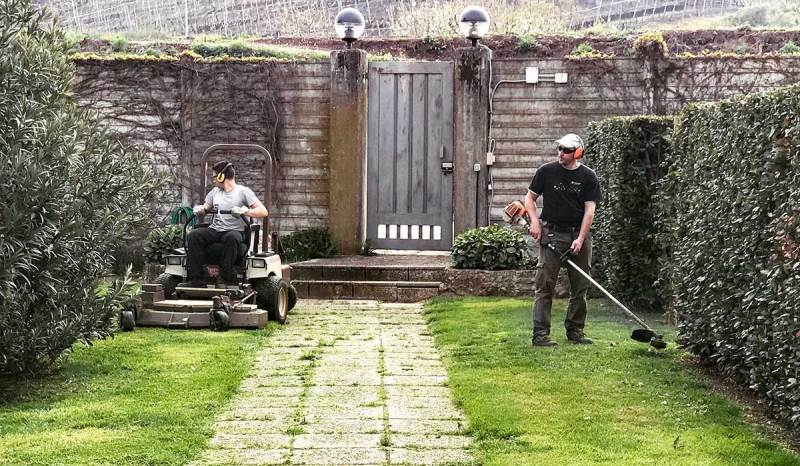 Two land care business owners working on customer’s lawn