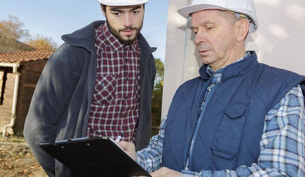 A construction bond can help you land more work, like this construction manager and his employee.