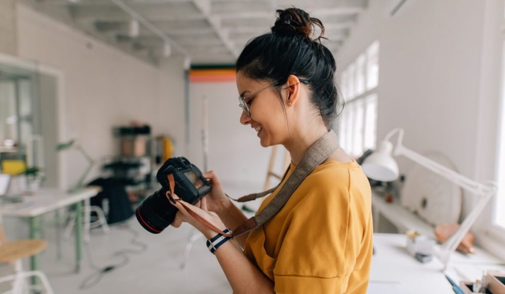 A self-employed photographer looks at a photo she just took.