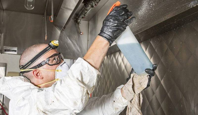 Man figured how to bid on a cleaning job and is wearing protective gear to clean a restaurant's kitchen