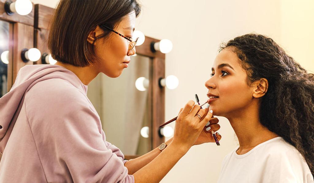 Once you learn how much do makeup artists make, you can work as a makeup artist, like this woman working on a client.